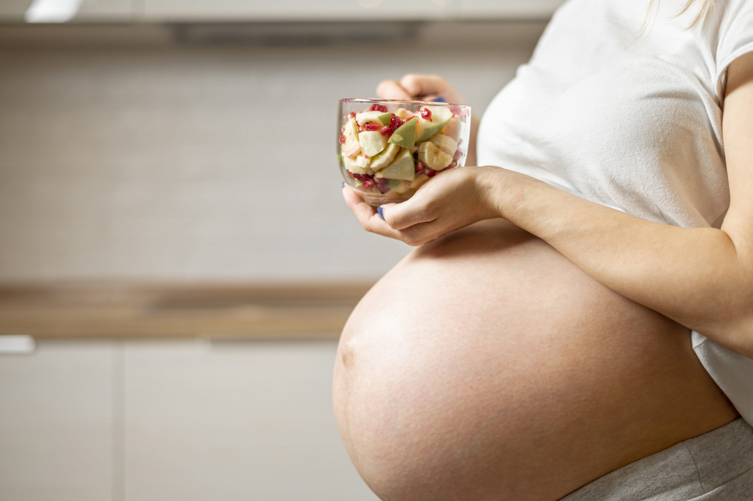 Gestante preparando aveia com frutas para aliviar o intestino preso na gravidez